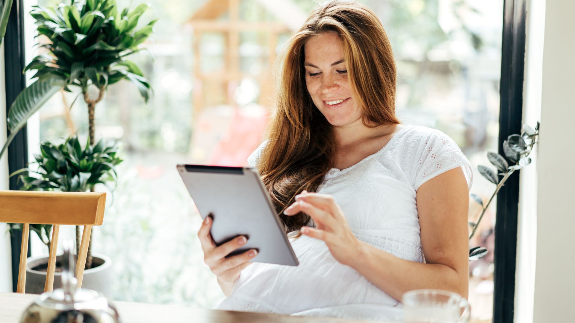 smiling woman using a tablet to pay rent
