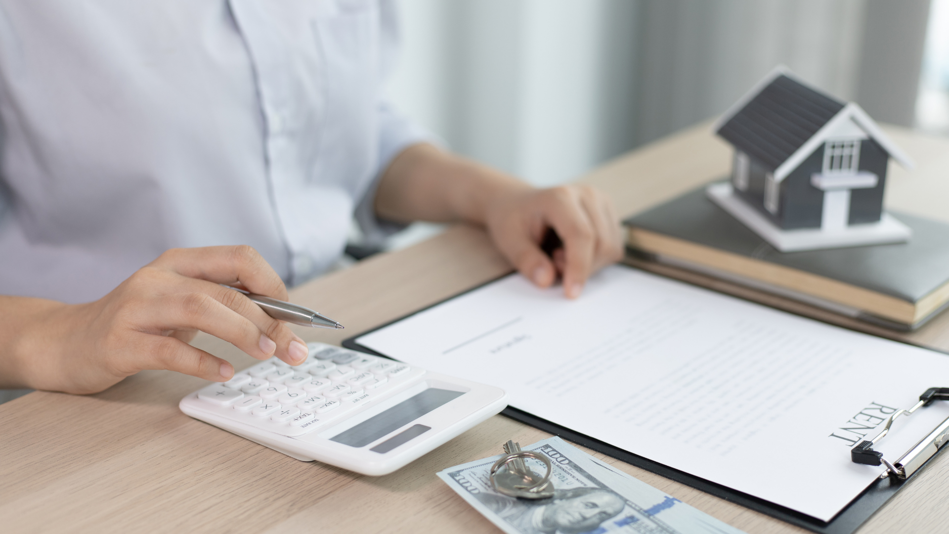 property manager using a calculator at their desk and writing on a document