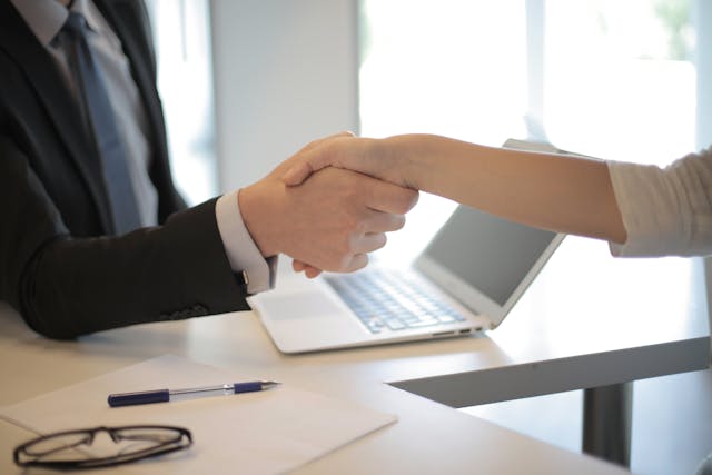 two people shaking hands over documents (2)