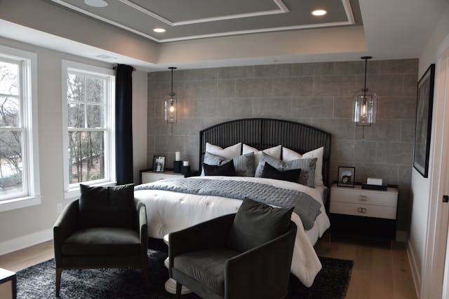 Bedroom with large bed and two black chairs
