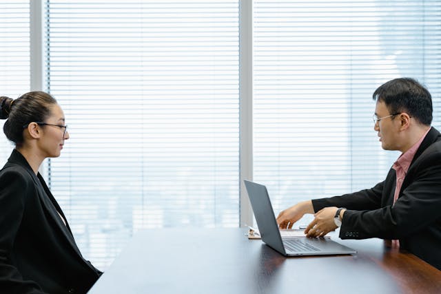 Two people talking over a computer