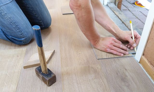 person replacing floor boards