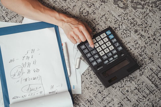 person crunching numbers using a calculator