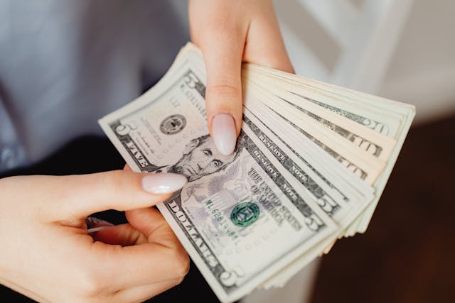 Person couning a stack of money