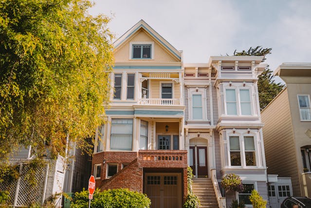 A yellow townhouse with driveway