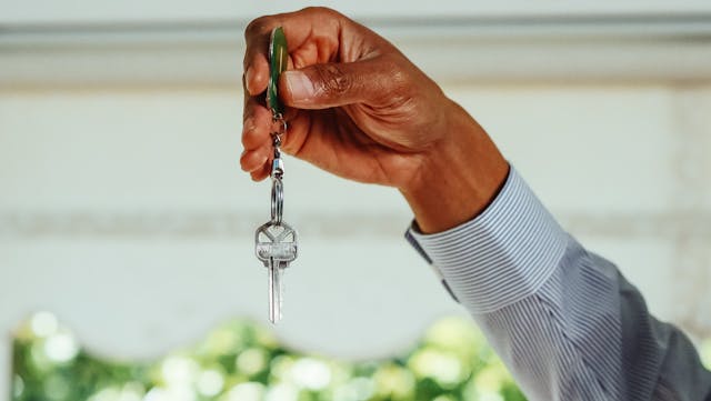 person holding up a set of house keys
