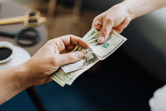 two people passing money to eachother
