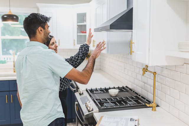 Two people inspecting a stove top